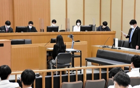 被告役の女性を前に、審理に臨む裁判官（右）と裁判員役の高校生＝神戸地裁
