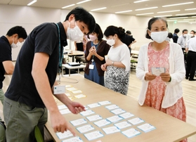 カーボンニュートラルを学ぶカードゲームに取り組む参加者ら＝大阪市中央区