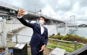 大鳴門橋をバックに「自撮り」する斎藤元彦知事＝南あわじ市福良丙