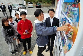 兵庫高校に設置された「おしゃべり自販機」で飲み物を買う生徒ら。斎藤知事の声でメッセージが流れる＝神戸市長田区寺池町１