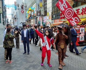 注目を浴びながら繁華街を歩くアルミカン赤阪侑子さん（手前左）と「河童のガジロウ」＝大阪市内