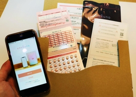 アプリ「スマルナ」の画面と、利用者に届けられるピルのセット＝大阪市北区（画像の一部を加工しています）