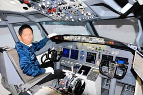 ボーイング７３７のフライトシミュレーターに座る伊藤世一社長。この操縦席で、朝ドラ「舞いあがれ！」第１話の冒頭シーンが撮影された＝神戸市長田区神楽町２、「テクノバード」