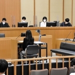 被告役の女性を前に、審理に臨む裁判官（右）と裁判員役の高校生＝神戸地裁