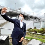 大鳴門橋をバックに「自撮り」する斎藤元彦知事＝南あわじ市福良丙