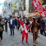 注目を浴びながら繁華街を歩くアルミカン赤阪侑子さん（手前左）と「河童のガジロウ」＝大阪市内