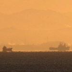 空気の揺らぎで宙に浮かんで見える船＝２６日早朝、神戸市須磨区から（撮影・吉田敦史）