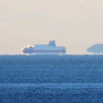 空気の揺らぎで海面から浮かんで見える島や船＝２６日午前、神戸市須磨区から（撮影・吉田敦史）