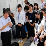 明石歩道橋事故の現場の歩道橋で、事故について明石市の若手職員に語る遺族の下村誠治さん（左端）＝２０１７年７月、明石市大蔵海岸通１