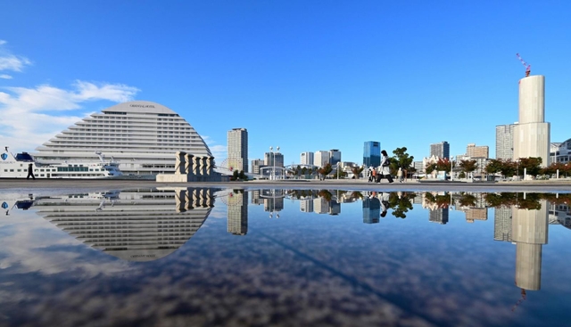 雨が生み出した「水鏡」の置き土産。空にも足元にも秋空が広がった＝２日午前、神戸市中央区波止場町
