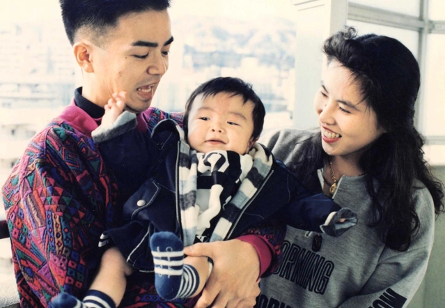 幼い中村翼さんをあやす父威志さんと母ひづるさん（中村さん提供）