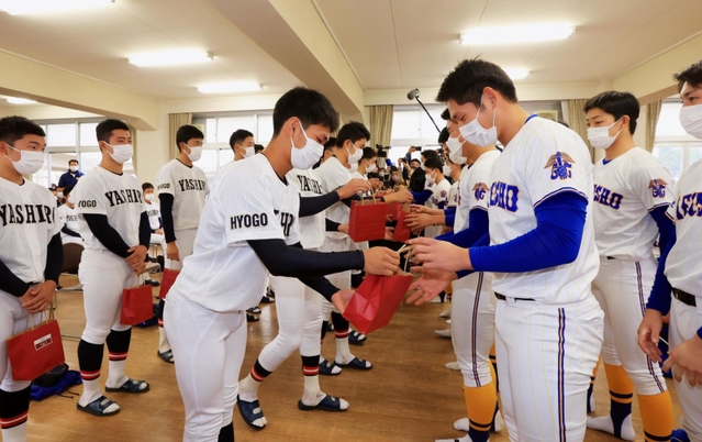 県岐阜商の選手たちにプレゼントを手渡す社の選手たち＝２３日午前、加東市木梨、社高校（撮影・鈴木雅之）