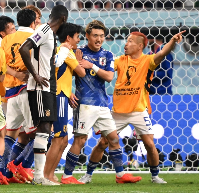 ドイツに勝利し、チームメートと喜ぶ堂安律（中央）＝カタール・ハリファ国際スタジアム（撮影・金田祐二）