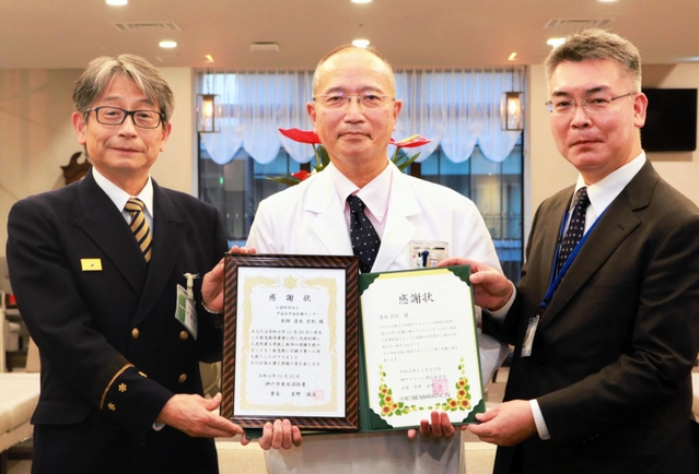 神戸マラソンでランナーの心肺蘇生を行い感謝状を受け取る甲南医療センター参事の清水宏紀さん（中央）＝神戸市東灘区鴨子ケ原１