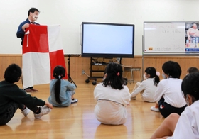 津波フラッグの説明を聞く県立神戸聴覚特別支援学校の児童ら＝神戸市垂水区福田１