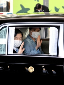 車から手を振られる天皇、皇后両陛下＝１２日午後、神戸市中央区の神戸空港（代表撮影）