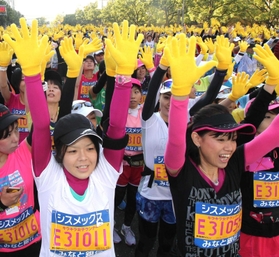 第４回大会のスタート前セレモニーで黄色い手袋を着け、両手を挙げるランナーたち＝２０１４年１１月２３日、神戸市中央区磯辺通４