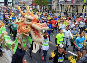 龍舞のエールを受けながら走るランナー＝２０日午前、神戸市中央区（撮影・鈴木雅之）