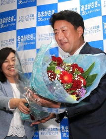 初当選を確実にし稲村和美市長（左）から花束を受け取る松本真氏＝２０日午後、尼崎市七松町３（撮影・斎藤雅志）