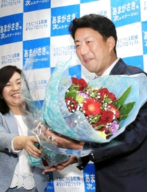 初当選を確実にし、稲村和美市長（左）から花束を受け取る松本真氏＝２０日夜、尼崎市七松町３（撮影・斎藤雅志）