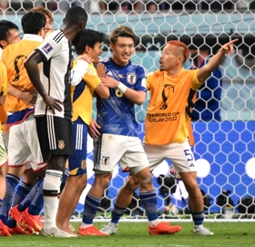 ドイツに勝利し、チームメートと喜ぶ堂安律（中央）＝カタール・ハリファ国際スタジアム（撮影・金田祐二）