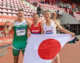 世界マスターズ陸上競技選手権で優勝し、日の丸を手にする福田博之さん（右）＝７月、フィンランド・タンペレ（本人提供）
