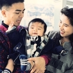 幼い中村翼さんをあやす父威志さんと母ひづるさん（中村さん提供）