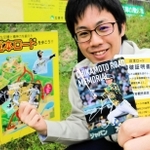「近本ロード」の看板前でカードを持つ加東市職員＝加東市山口