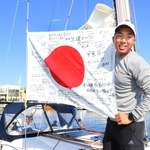 応援メッセージが書かれた日の丸をヨットに取り付け、笑顔を見せる木村啓嗣さん＝１２日午後、西宮市西宮浜４、新西宮ヨットハーバー（撮影・斎藤雅志）