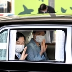 車から手を振られる天皇、皇后両陛下＝１２日午後、神戸市中央区の神戸空港（代表撮影）