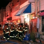 火災が起きた建物の状況を確認する消防隊員＝１５日午後９時３６分、長田区長楽町４