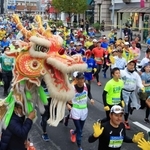 龍舞のエールを受けながら走るランナー＝２０日午前、神戸市中央区（撮影・鈴木雅之）