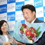 初当選を確実にし、稲村和美市長（左）から花束を受け取る松本真氏＝２０日夜、尼崎市七松町３（撮影・斎藤雅志）