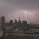 灰色の雲の中から市街地へ落ちる雷＝23日午後、神戸市中央区東川崎町１から（撮影・長嶺麻子）