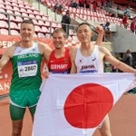 世界マスターズ陸上競技選手権で優勝し、日の丸を手にする福田博之さん（右）＝７月、フィンランド・タンペレ（本人提供）