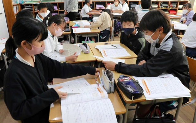 アッコちゃんが登場する副読本を読み、お母さんの気持ちについて話し合う児童たち＝西灘小学校