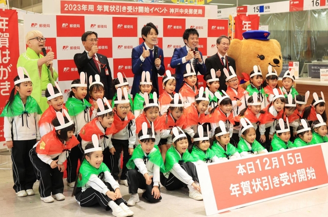 年賀状の引き受け開始をＰＲする熊内幼稚園の園児と桂きん太郎さん（後列左）、お笑いコンビ「スマイル」の２人（同中央）＝１５日午前、神戸市中央区栄町通６、神戸中央郵便局（撮影・吉田敦史）