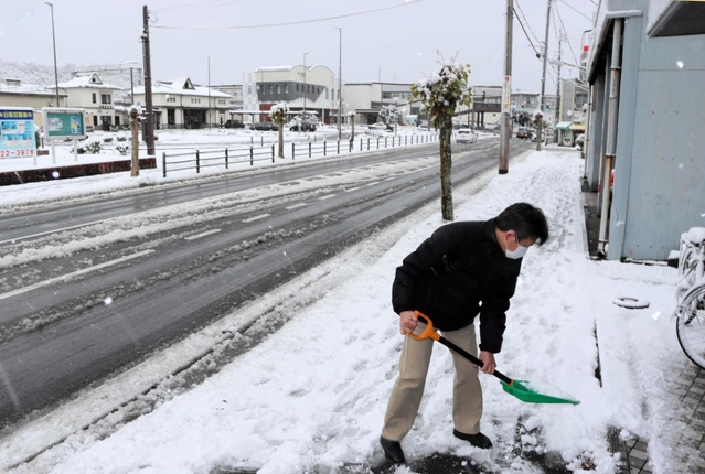 歩道の雪かきを行う住民＝１８日午前、豊岡市大手町（撮影・丸山桃奈）
