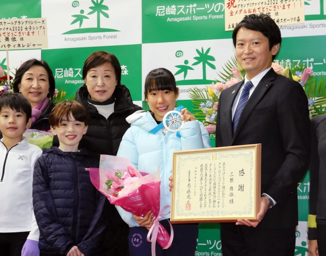 金メダルを手に、斎藤元彦知事（右端）や後輩スケーターらと記念写真に納まる三原舞依選手（右から２人目）＝尼崎市扇町