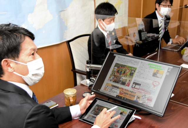 タブレット端末を使って内部協議を行う斎藤元彦知事（左）＝兵庫県庁