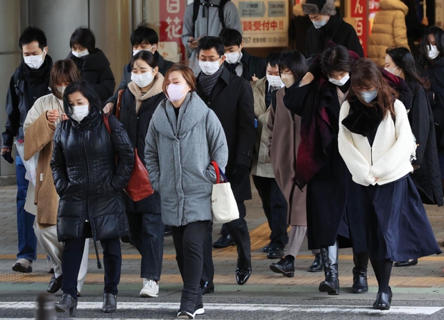 冷たい風に身を縮める人たち＝２３日午前、神戸市中央区三宮町１