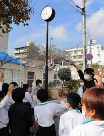 校門横で時を刻む「アッコちゃんの時計」＝神戸市灘区船寺通３、西灘小学校