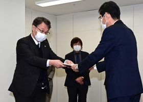 長田淳教育長（手前）に報告書を提出する調査委員会の松本隆行委員長＝９日午前、神戸市中央区東川崎町１（撮影・中西幸大）
