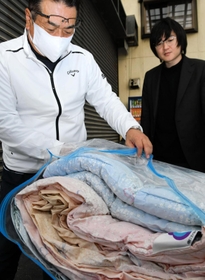 回収した古い布団を確かめる内橋毅さん（左）と堅志さん＝西脇市和布町