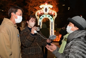 来場者に阪神・淡路大震災の経験を聞く「１・１７希望の架け橋」の藤原祐弥さん（左）ら＝１０日夜、神戸市中央区加納町６（撮影・秋山亮太）