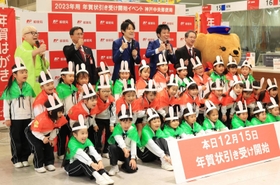 年賀状の引き受け開始をＰＲする熊内幼稚園の園児と桂きん太郎さん（後列左）、お笑いコンビ「スマイル」の２人（同中央）＝１５日午前、神戸市中央区栄町通６、神戸中央郵便局（撮影・吉田敦史）