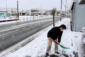 歩道の雪かきを行う住民＝１８日午前、豊岡市大手町（撮影・丸山桃奈）