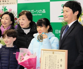 金メダルを手に、斎藤元彦知事（右端）や後輩スケーターらと記念写真に納まる三原舞依選手（右から２人目）＝尼崎市扇町