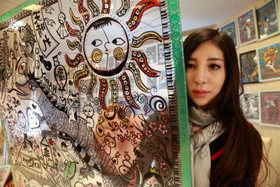 アクリル板に絵を描く橋本薫さん。「コロナ禍の負の遺産の活用はＳＤＧｓにもつながる」＝神戸市中央区小野柄通８