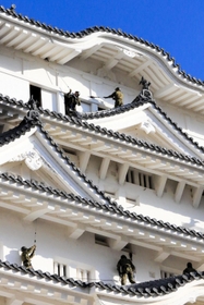 姫路城大天守の屋根に乗って清掃するレンジャー隊員＝姫路市本町